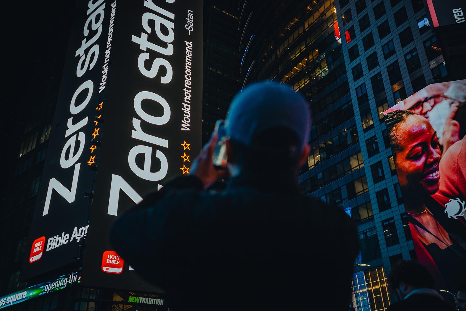 Times Square ad shows a fake Bible App review that says “Zero stars. – Satan”